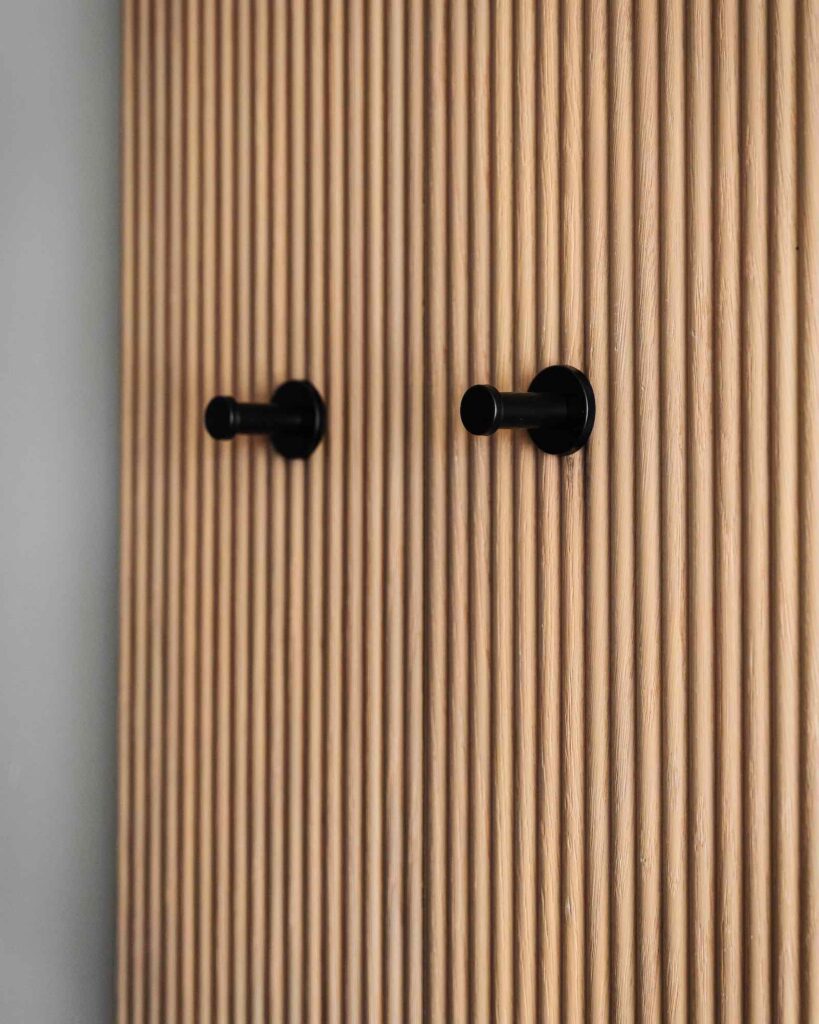 Tuttavia, come sempre, molto dipende dal gusto e dallo stile della casa, pertanto è anche possibile optare per delle boiserie con appendiabiti, come nel caso di questa che vedi in foto della nostra collezione Segno, che è stata qui utilizzata per rivestire una parete della cabina armadio e per inserirci degli appendiabiti, appunto.